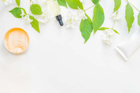 Flat lay composition with cosmetics and jasmine flowers on a light backgroundの写真素材