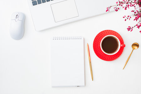 Mockup open white notepad with cup of coffee, branches with red berries, laptop on a white backgroundの写真素材