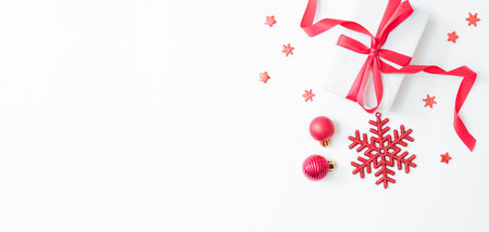Flat lay frame with red berries, christmas red balls and gift box on a white background. Christmas and New Year banner with copy space for your textの写真素材