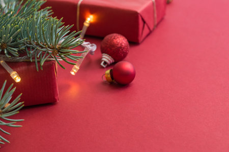 Frame with fir branches, christmas balls and gift box on a red backgroundの写真素材
