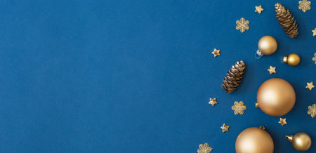 Christmas holiday banner background with copyspace. Flat lay frame with christmas balls and decorations on a blue backgroundの写真素材