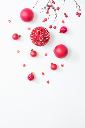 Flat lay frame with red berries, christmas red balls on a white background. Merry christmas card and copy space for your textの写真素材