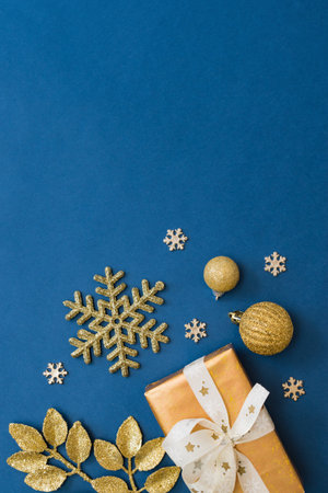 Christmas holiday banner background with copyspace. Flat lay frame with christmas balls and gift box on a blue backgroundの写真素材