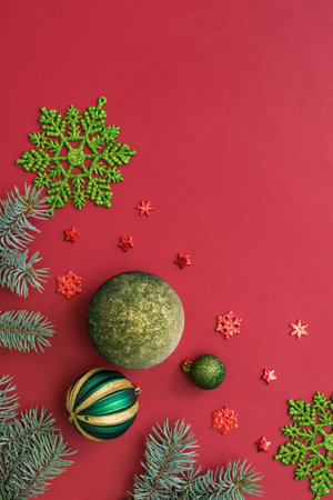 Flat lay frame with fir branches and christmas balls on a red backgroundの写真素材
