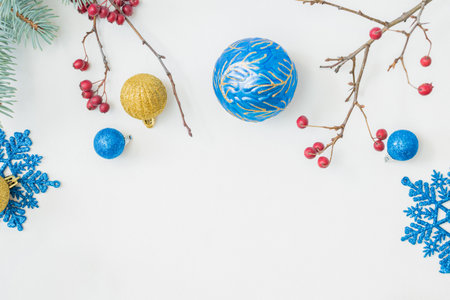 Flat lay frame with christmas balls, red berries, snowflakes on a white background. Merry christmas card and copy space for your textの写真素材