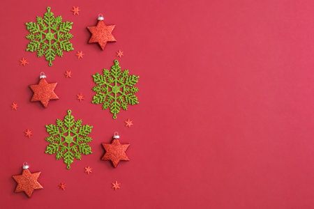 Flat lay border with snowflakes and christmas decoration on a red backgroundの写真素材