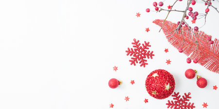 Flat lay christmas frame with red berries, snowflakes and red balls on a white background. Christmas and New Year banner with copy space for your textの写真素材