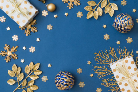 Christmas holiday composition. Flat lay frame with christmas balls and gift box on a blue backgroundの写真素材