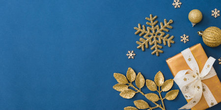 Christmas holiday banner background with copyspace. Flat lay frame with christmas balls and gift box on a blue backgroundの写真素材