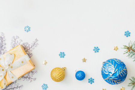 Flat lay frame with christmas balls, fir branches, snowflakes and gift box on a white background. Merry christmas card and copy space for your textの写真素材