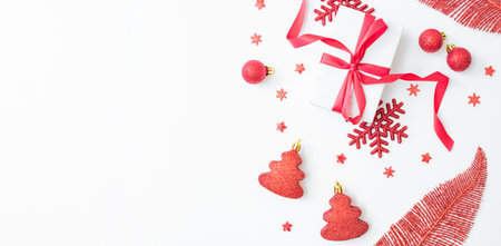 Flat lay christmas frame with red berries, snowflakes and gift box on a white background. Christmas and New Year banner with copy space for your textの写真素材