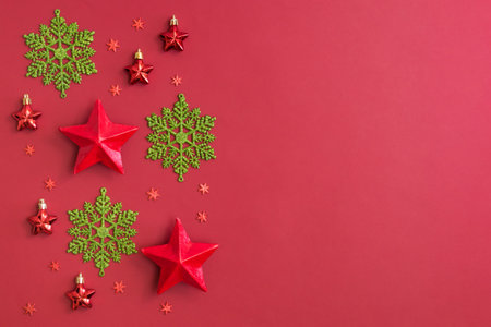 Flat lay border with snowflakes and christmas decoration on a red backgroundの写真素材