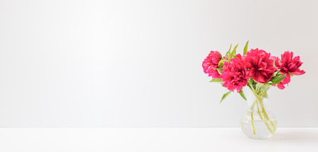 Home interior decor elements. Red peonies in a vase on a white table with copy space. Mock up for display worksの写真素材