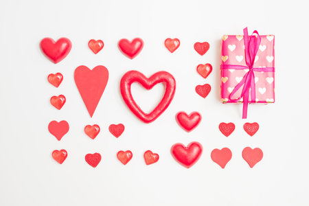 Flat lay valentines day pattern with gift box and red hearts on a white background. valentine's day greeting cardの写真素材