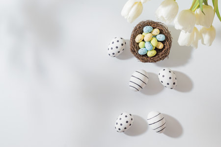 Flat lay easter composition with white tulips in a vase and easter eggs ...