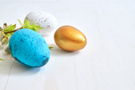 Branches with buds and green leaves, easter eggs on a light background. Happy easter concept with copy spaceの写真素材