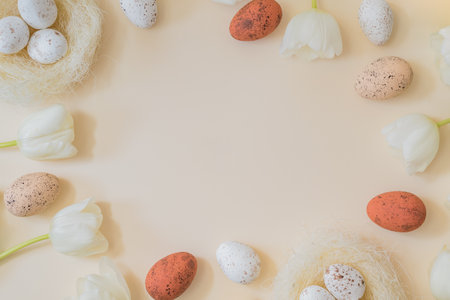 Flat lay easter composition with white tulips and easter eggs on a beige backgroundの写真素材