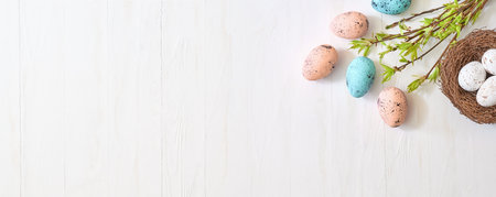 Branches with green leaves and easter eggs on a light background. Happy easter flat lay conceptの写真素材