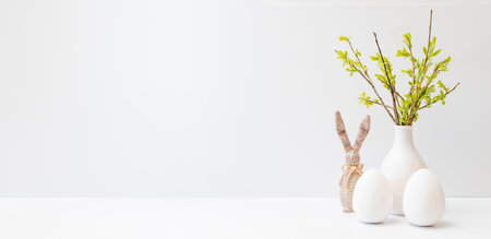 Willow branches in a vase and easter eggs on a light background. Easter background with copy spaceの写真素材