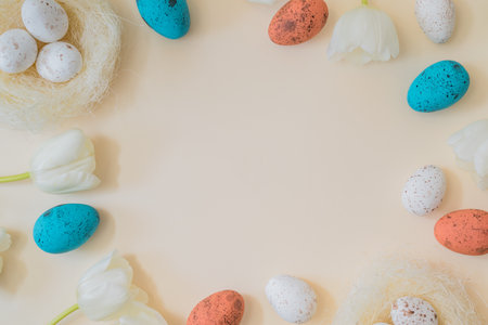Flat lay easter composition with white tulips and easter eggs on a beige backgroundの写真素材
