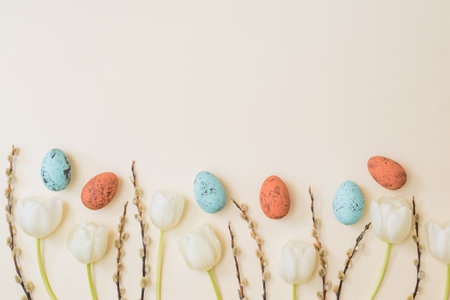 Flat lay easter composition with white tulips and easter eggs on a beige backgroundの写真素材