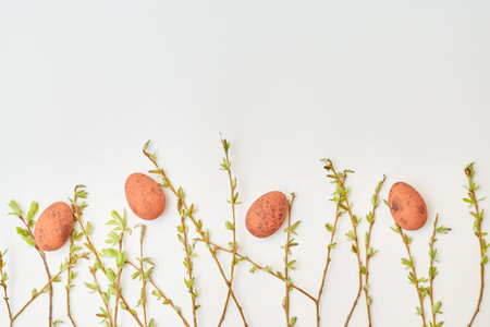 Flat lay easter composition with buds and green leaves, easter eggs on a white background. Happy easter concept with copy spaceの写真素材