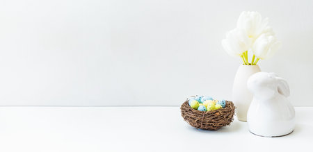 White spring tulips in a vase, easter eggs on a white table. Mock up for display worksの写真素材