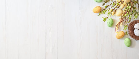 Branches with green leaves and easter eggs on a light background. Happy easter flat lay conceptの写真素材