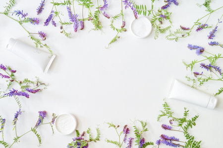 Flat lay frame with skin care products and wildflowers on white backgroundの写真素材