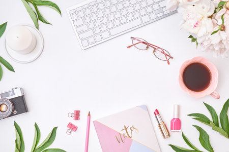 Fashion blogger workspace with notepad, glasses, cup of coffee, keyboard and white peonies on a light background. Flat lay banner or shop header template for blogの写真素材