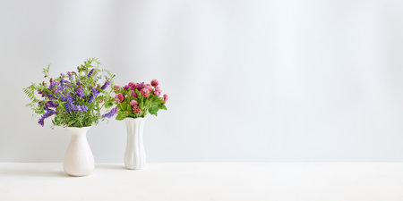 Wildflowers in a vase on a white table. Mock up for display worksの写真素材