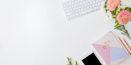 Flat lay home office desktop with smartphone, notebook, flowers in a vase, office supplies on a light background. Top view banner background with copy spaceの写真素材