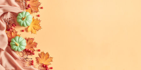 Flat lay frame with colorful autumn leaves and pumpkins on an orange backgroundの写真素材