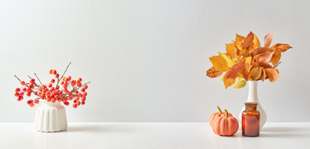 Home interior with decor elements. Colorful autumn leaves in a vase on a light background. Mock up for display worksの写真素材