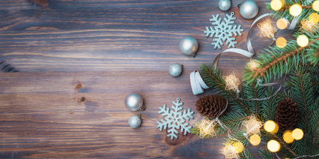 Flat lay christmas composition with fir branches and christmas decorations, garland on a wooden table. Winter holiday background with copy spaceの写真素材