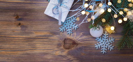 Flat lay christmas composition with white branches and gift box on a wooden table. Winter holiday background with copy spaceの写真素材