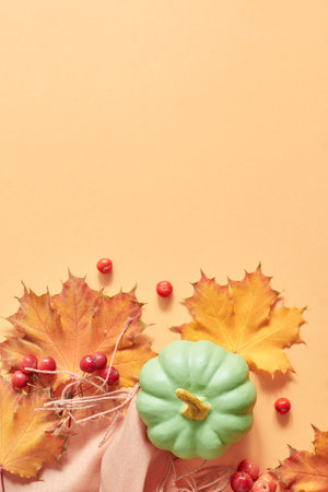 Flat lay frame with colorful autumn leaves and pumpkins on an orange backgroundの写真素材