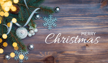 Flat lay christmas composition with fir branches and christmas decorations, garland on a wooden table. Winter holiday background with text merry christmas