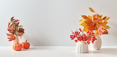 Home interior with decor elements. Colorful autumn leaves in a vase on a light background. Mock up for display worksの写真素材