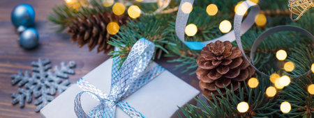 Christmas composition with fir branches and Christmas decorations, gift box on a wooden table. Winter merry christmas holiday greeting cardの写真素材