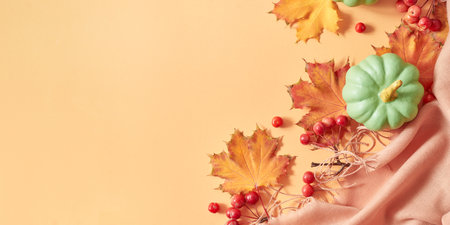Flat lay frame with colorful autumn leaves and pumpkins on an orange backgroundの写真素材