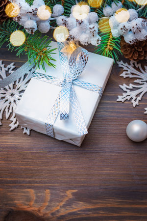 Christmas composition with fir branches and gift box, garland on a wooden table. Winter merry christmas holiday greeting cardの写真素材