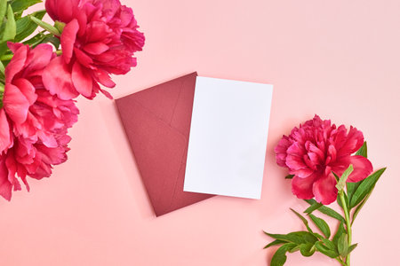 Mockup white greeting card and envelope with red peonies on a pink background. Valentines Day card for your textの写真素材