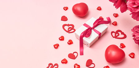 Valentines day frame with gift box and red hearts on a pink background. Valentines day banner with copy spaceの写真素材