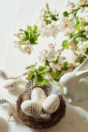 Holiday composition with spring flowers and easter eggs, white bunny on a light background. Happy easter concept with copy spaceの写真素材