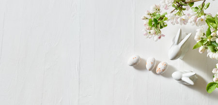 Holiday composition with spring flowers and easter eggs, white bunny on a light background. Happy easter flat lay concept with copy spaceの写真素材