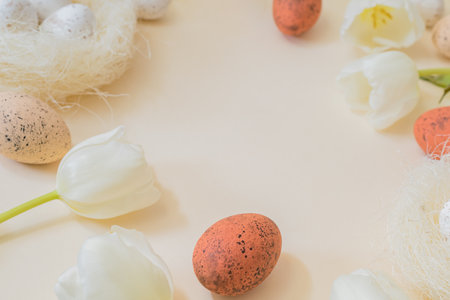 Easter composition with white tulips and easter eggs on a beige background