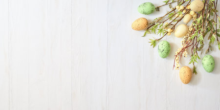 Branches with green leaves and easter eggs on a light background. Happy easter flat lay conceptの写真素材