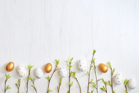 Branches with green leaves and easter eggs on a light background. Happy easter flat lay conceptの写真素材