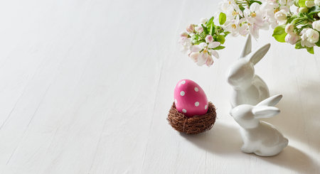 Holiday composition with spring flowers and easter eggs, white bunny on a light background. Happy easter concept with copy spaceの写真素材